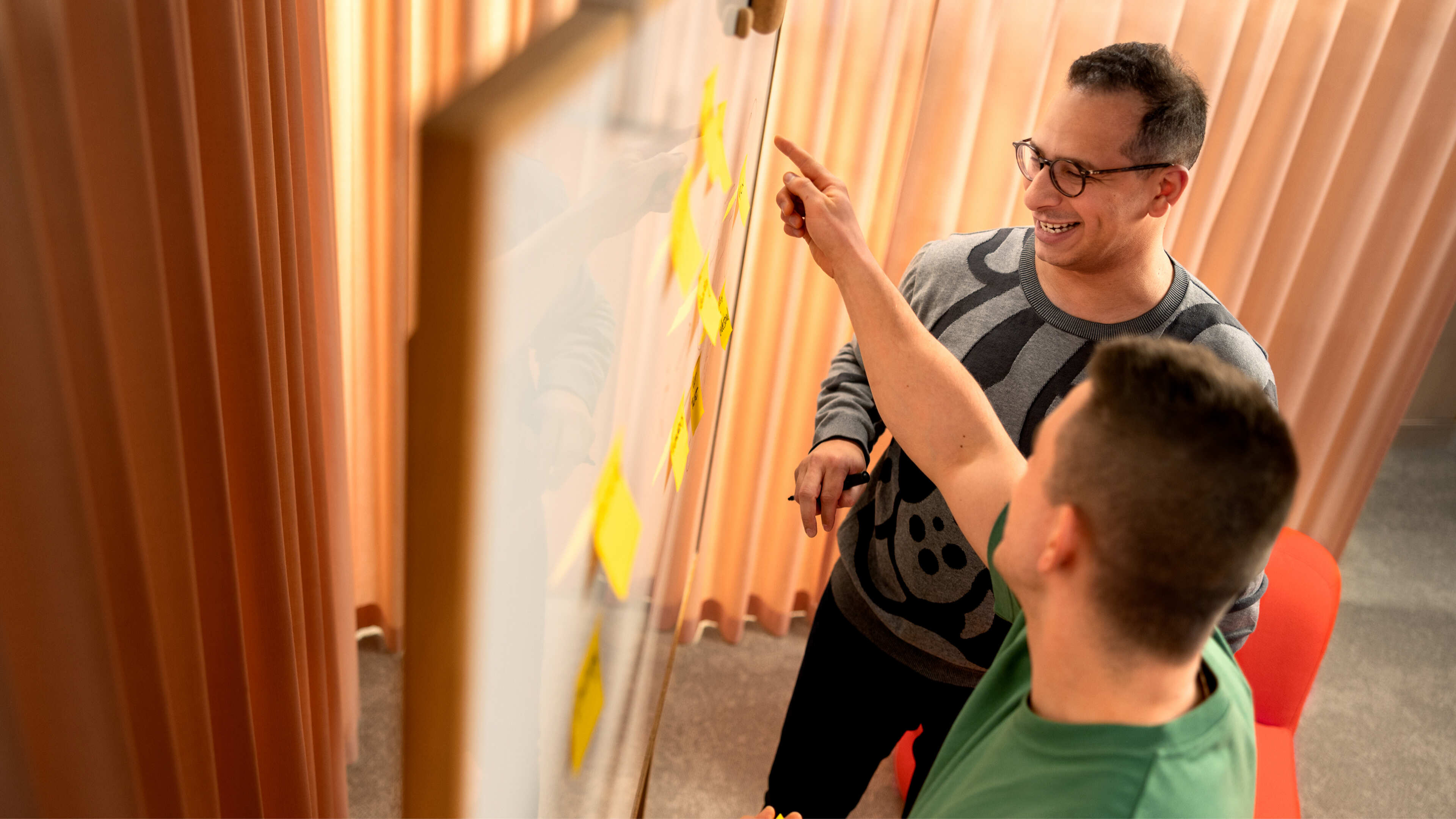 Two Metacore employees working at a whiteboard