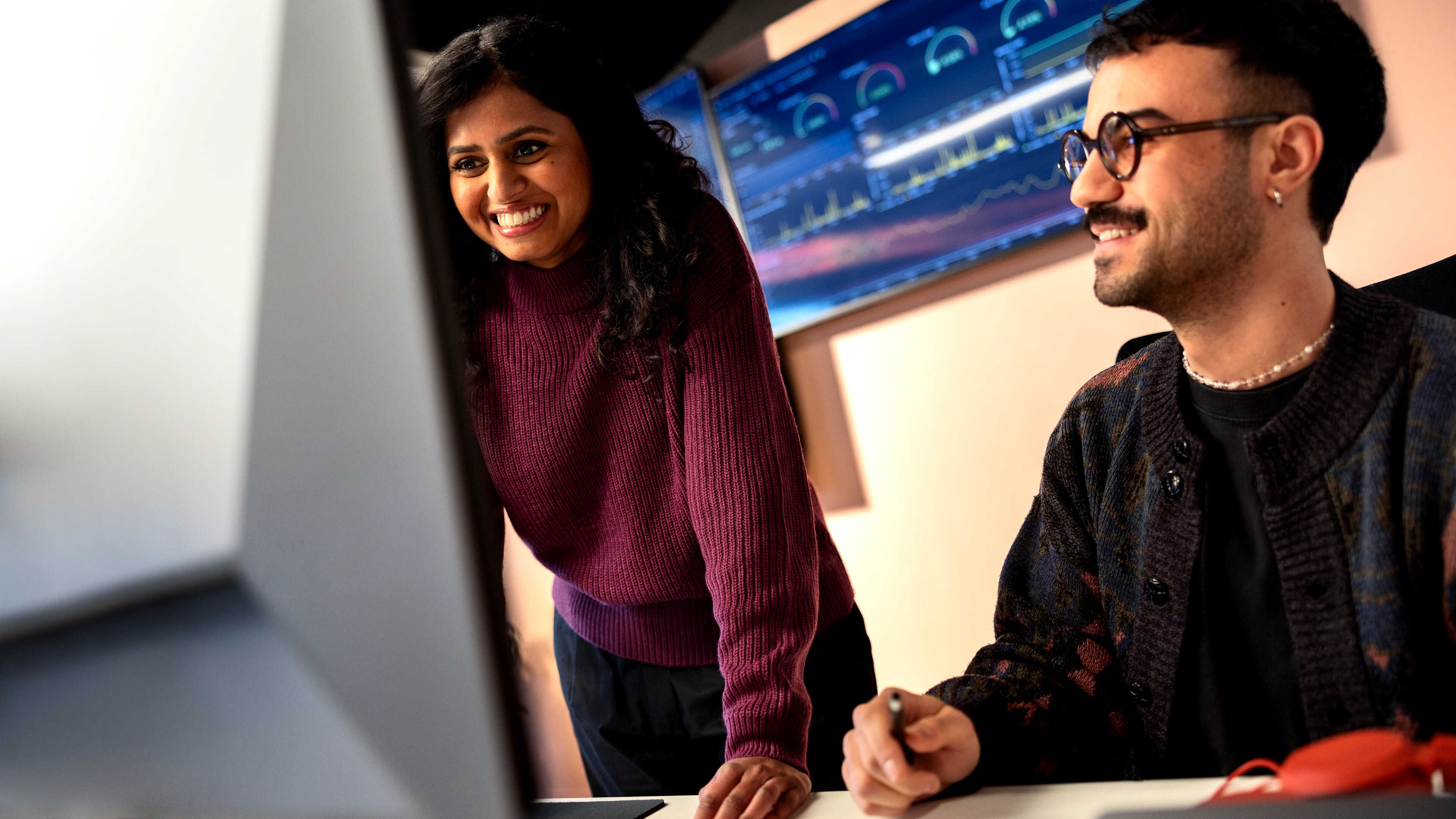 Two people collaborating in front of a whiteboard
